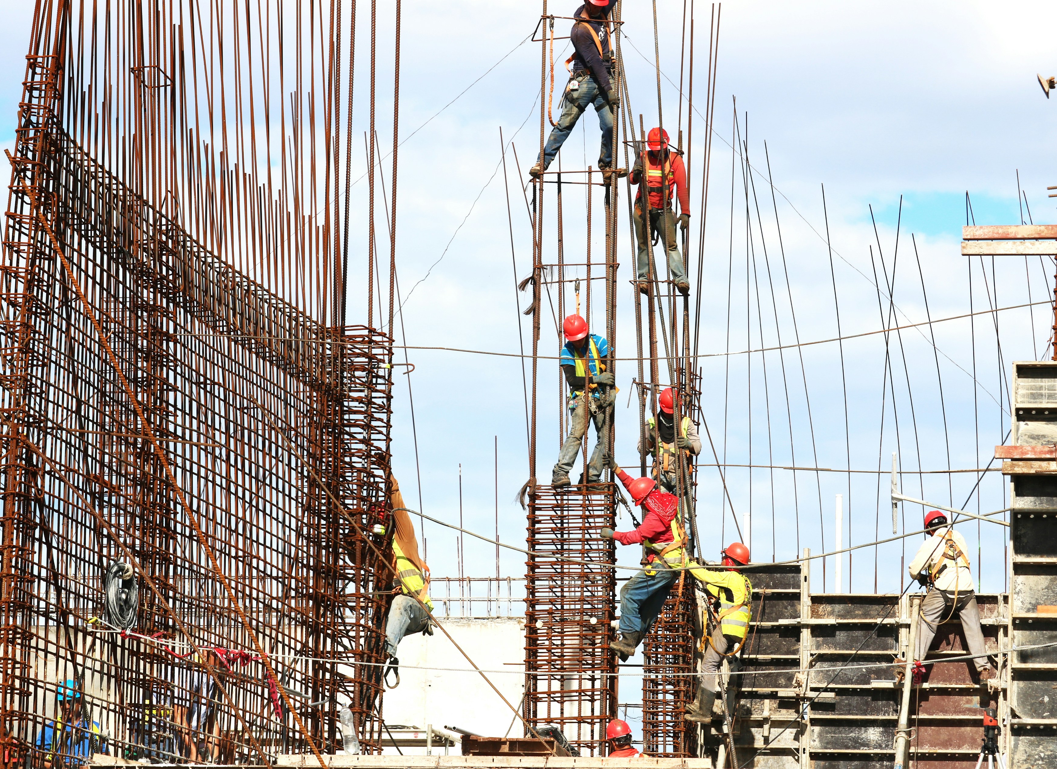 workers climbing a pillar at a construction site